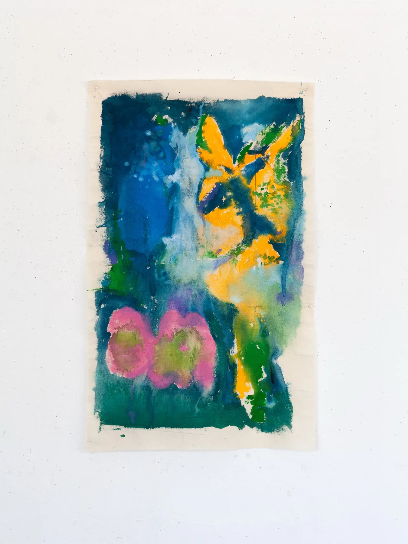 Vertical fabric painting on a white wall with a deep blue-green ground, orange-yellow floral bursts, and two pink blooms.