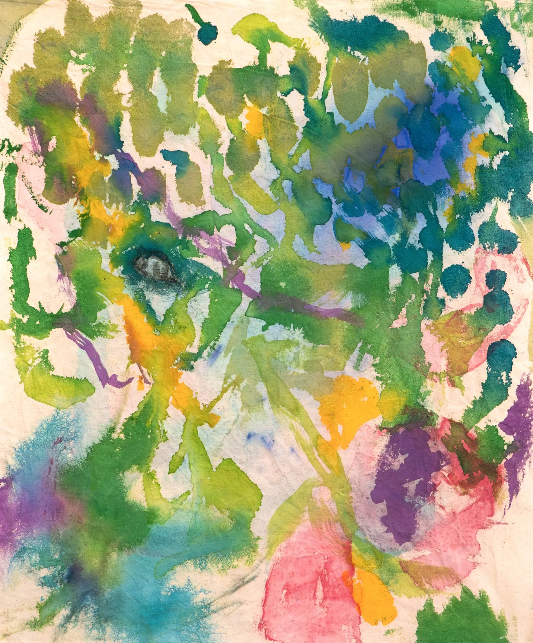 Close-up of a painted fabric filled with green, olive, blue, yellow, pink and purple dabs of color, with a single dark eye drawn among the greens.
